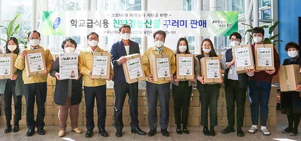 백군기 용인시장이 지난 19일 열린 ‘학교 급식용 친환경 농산물 꾸러미 판매’행사에 참석해 직원들과 함께 기념촬영을 하고 있다.