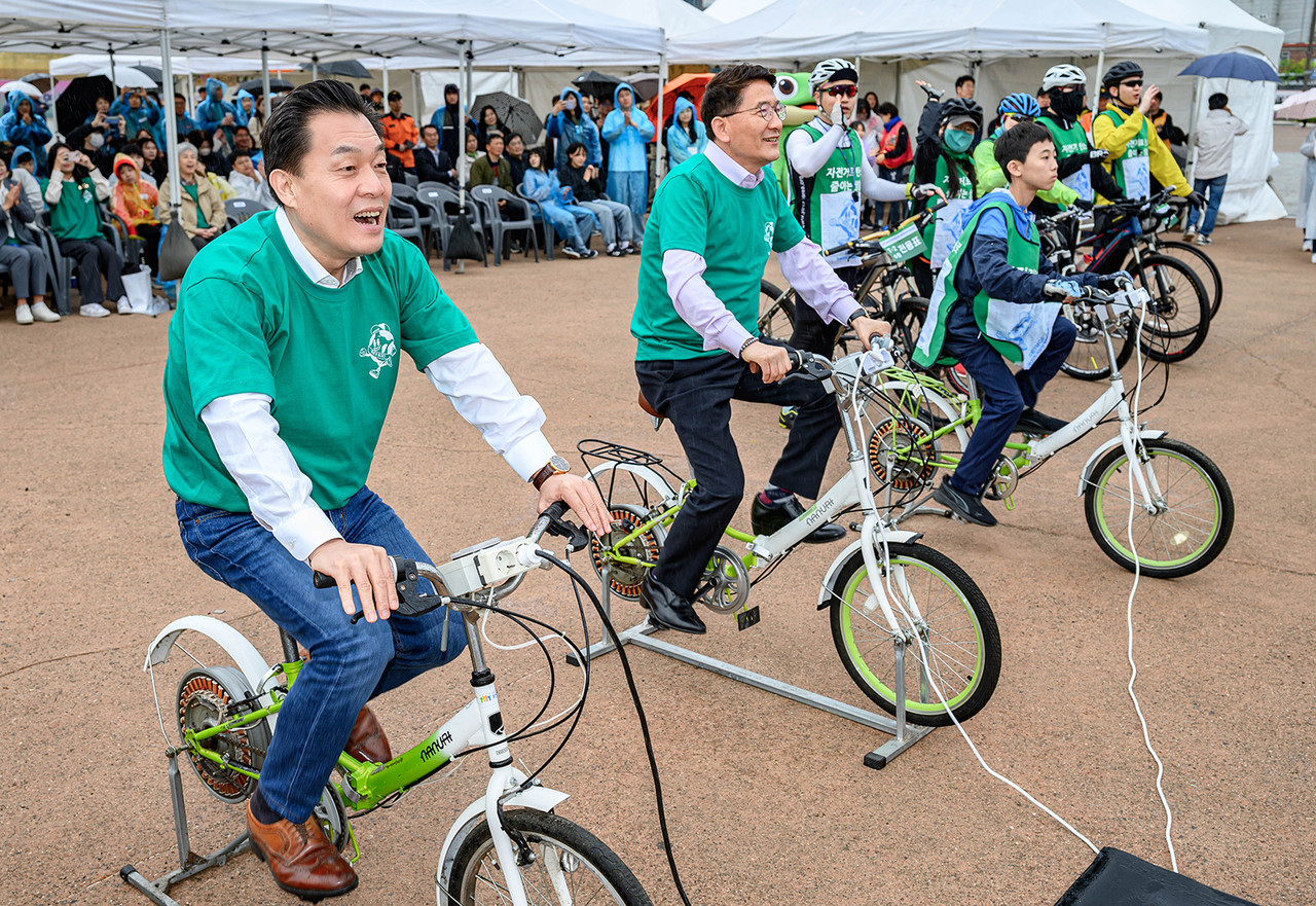 이재준 수원시장(왼쪽), 김기정 수원시의회 의장(왼쪽 2번째) 등이 지구의 날 기념행사에서 자전거로 전기를 만드는 체험을 하고 있다.    (사진제공=수원시)